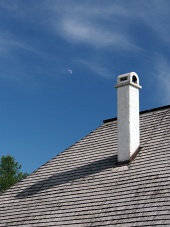 Šindľová strecha s komínom a mesiacom na oblohe