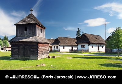 Drevená zvonica a ľudové domy v skanzene Pribylina